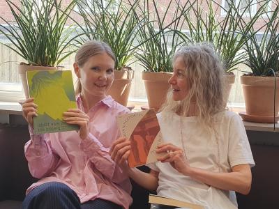 To kvinder i en sofa, begge med bøger